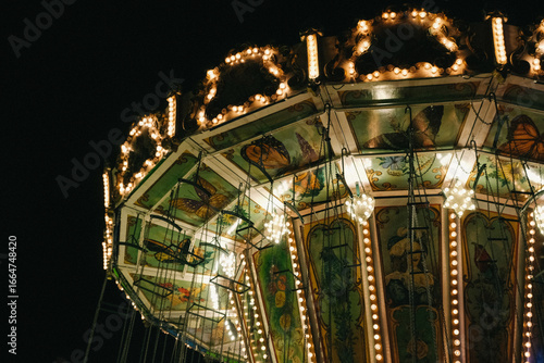 Children's carousels lit up. Luna Park. Evening or nighttime amusement park.