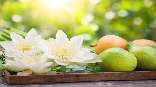 Fresh lotus flowers and ripe fruits arranged on a wooden tray