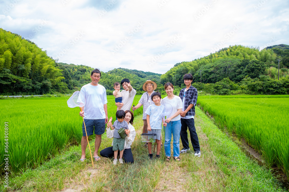 Obraz premium 夏休み帰省した故郷でみんなで遊ぶ 家族仲間の集合写真