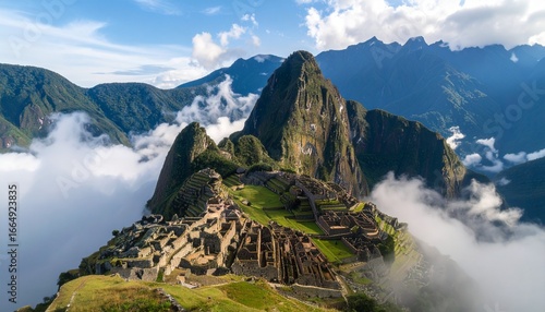 Stunning view of Machu Picchu in Peru surrounded by morning mist and clouds, with mountains rising in background.
