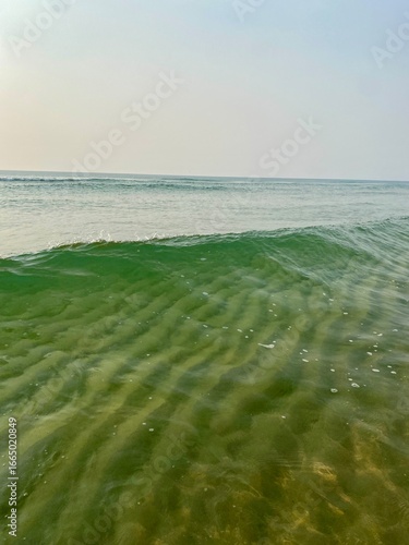 Crystal-clear ocean. Wave, sand and sky