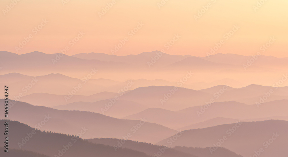 Fototapeta premium Softly lit mountain peaks in a hazy sunrise