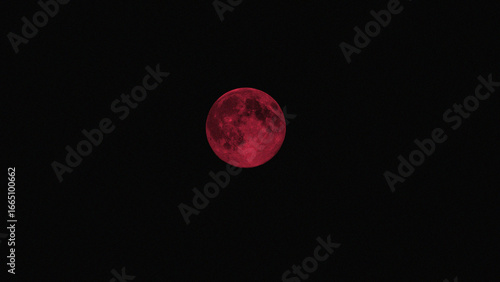 A bright red full moon on a black sky