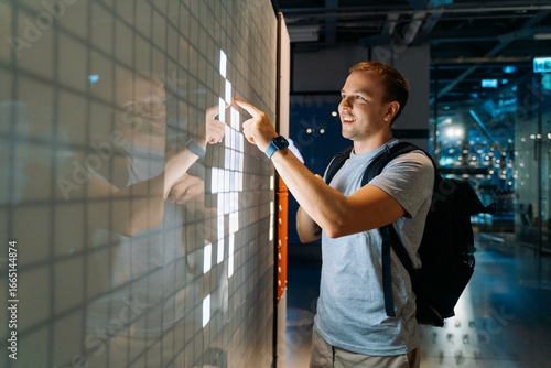 Man Using Interactive Touchscreen Display Indoors