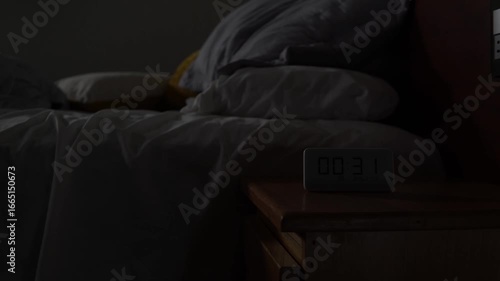 Man struggling with insomnia tossing and turning in bed