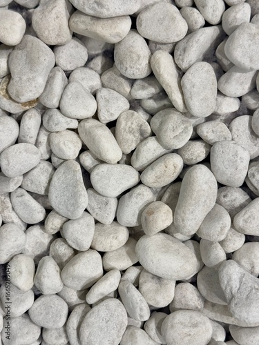 Close-up of smooth white pebbles, natural stone texture for decoration, landscaping. or background use stone wall background