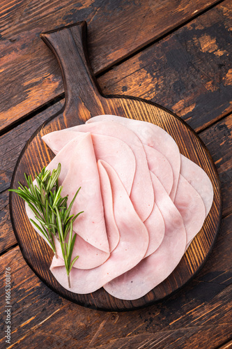 Close up of savory sliced ham showcasing its rich color and texture, a must-have for any deli lover. wooden background. top view
