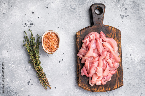 Fotografie Raw sliced Chicken meat, strips fillets on wooden board