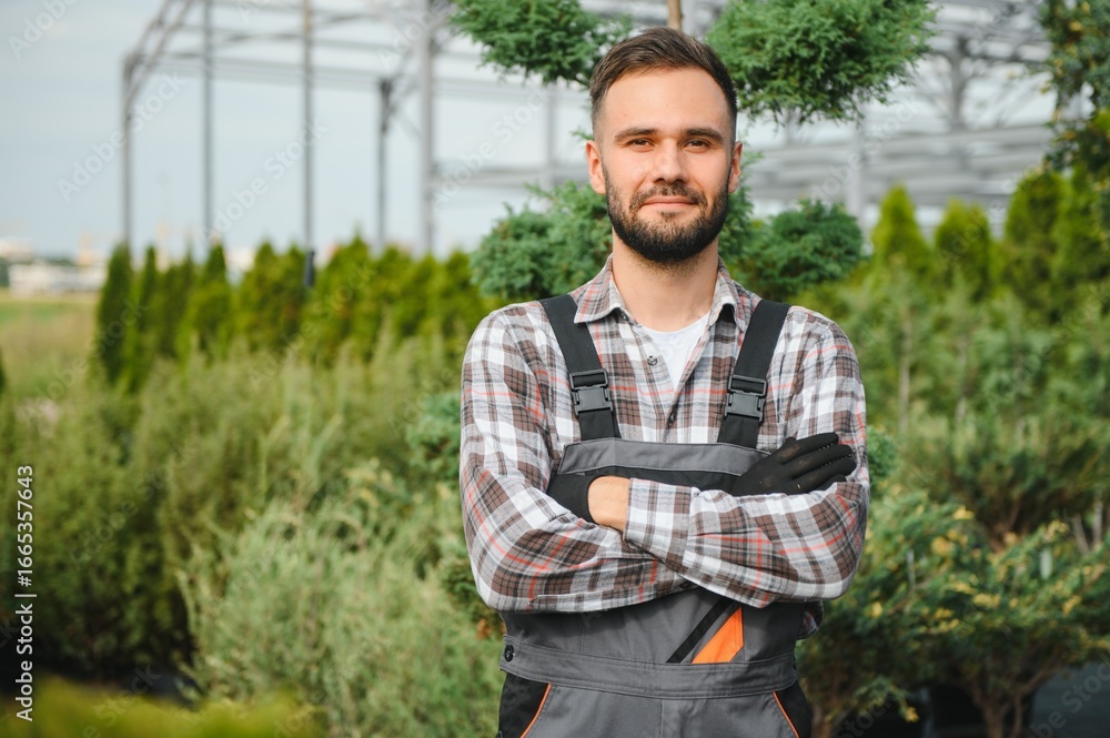 Fototapeta premium portrait of a young gardener on a plantation of bush seedlings.