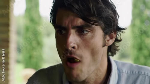 Italian man enjoys delicious pasta at rustic wooden table in sunlit Tuscan villa