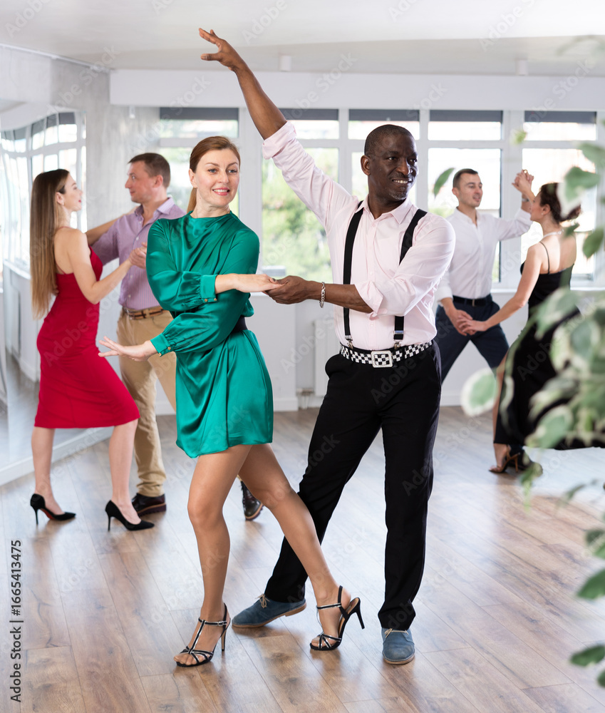 Fototapeta premium Elegant couples dancing tango, enjoying dance moves in dance salon