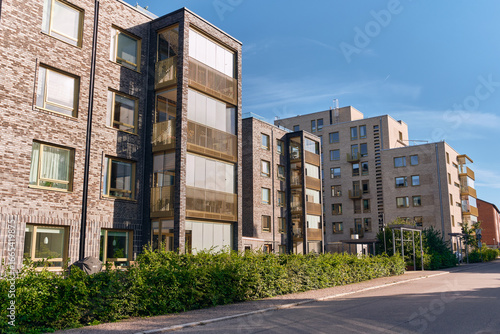 Two Modern Swedish apartment buildings with metallic brick facade and glass-enclosed balconies
