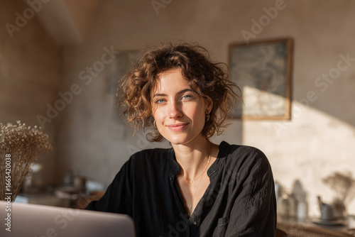 young woman in cozy cafe working on her laptop bathed in beam of sunlight embodying joy and inspiration