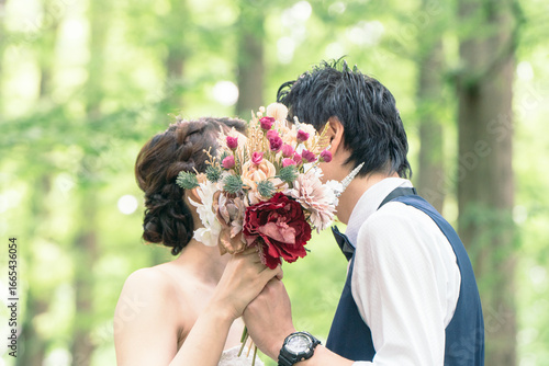 ブーケ越しにキスをする新郎新婦