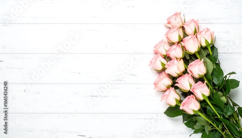 A bouquet of pale pink roses rests attractively on a white wooden surface, creating a gentle and romantic visual.