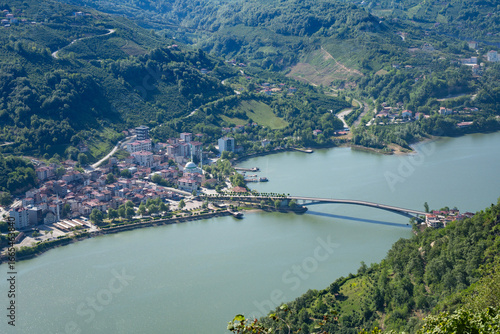 Aerial view of Eynel bridge over green lake in Ayvacik, Samsun, Turkey. Landscape of Ayvacik bridge connecting small town in black sea region. Tourism and travel concept