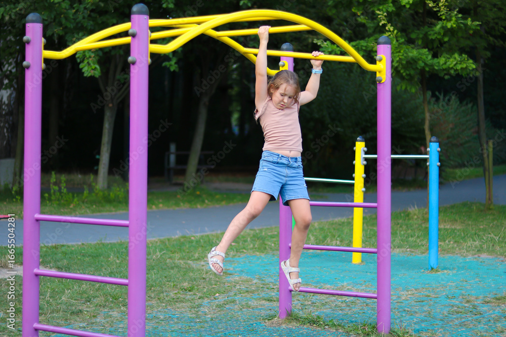 Fototapeta premium Girl playing on colorful playground equipment