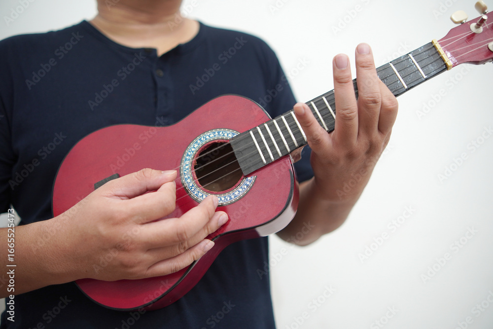 Fototapeta premium Asian man playing ukulele at home