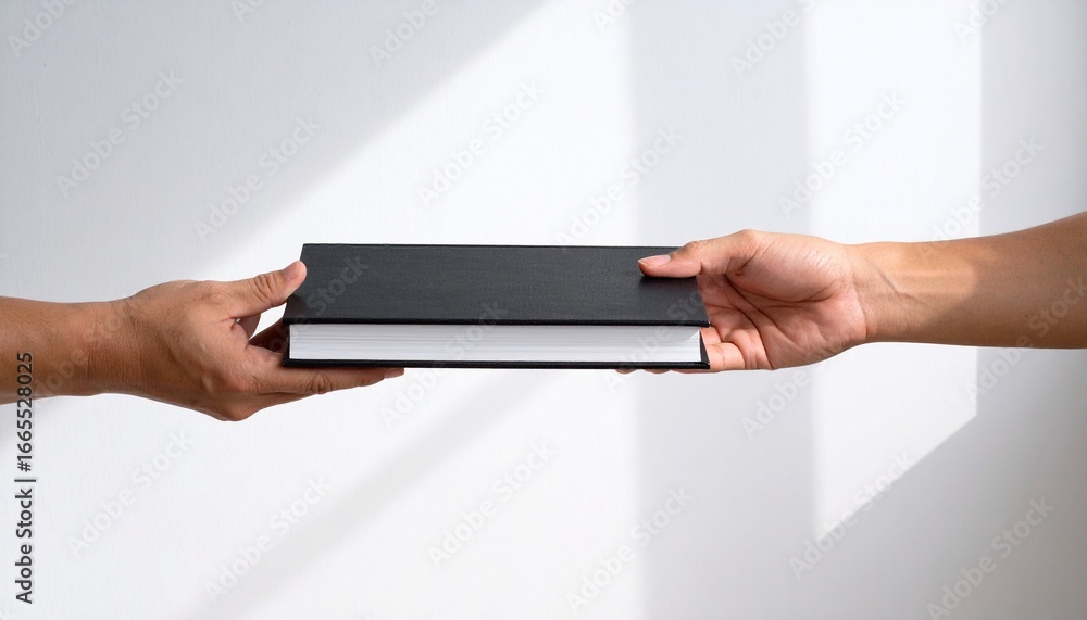 Hands passing a sleek black book, symbolizing knowledge transfer, education, and shared information in a modern setting Hands passing a sleek black book, symbolizing knowledge transfer, education, and shared information in a modern setting