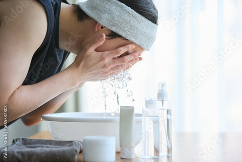 顔を洗う若いアジアの男性