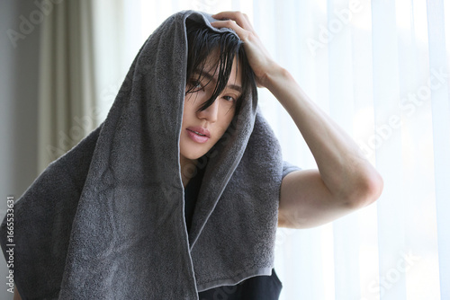 Photos 朝の窓際で入浴後のアジアの若い男性のポートレート