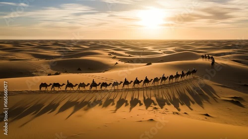 Wide shot of a long caravan of camels crossing a vast, sandy desert landscape at sunset, creating long shadows; 4k video footage with warm, golden tones.