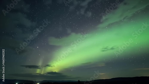 Wallpaper Mural Green northern lights dance above dark horizon under a starry sky with sparse clouds Torontodigital.ca
