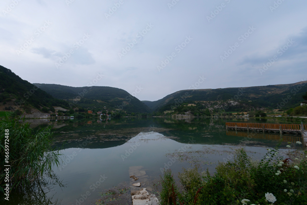 Fototapeta premium Located 11 kilometers north of the Göynük district, Çubuk Lake is 15 hectares wide and surrounded by beautiful pine forests, with Çubuk Village on its shores.