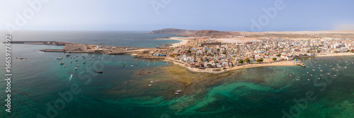 Wallpaper Mural Aerial view of the city of Sal Rei, luxury yachts moored in turquoise ocean,the port with many fishermen boats and its old color city, background the desert with the mountains. Torontodigital.ca