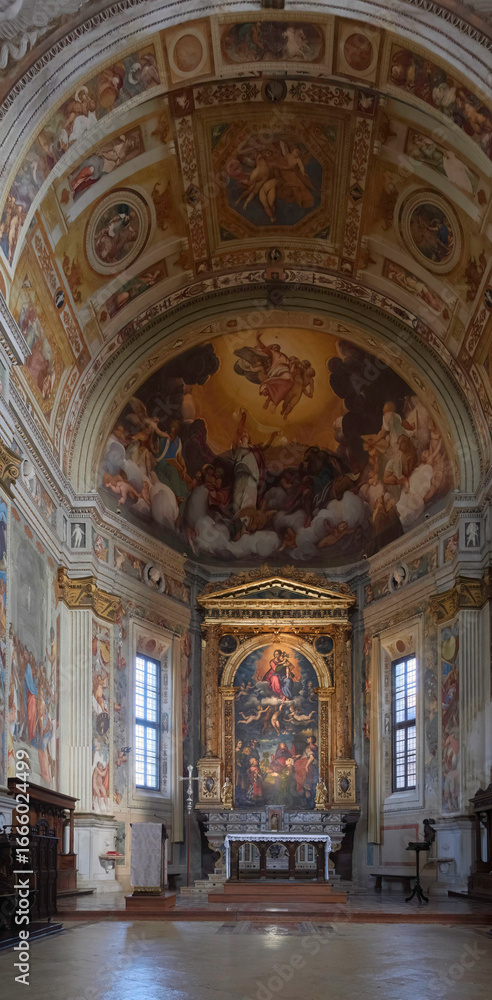 Obraz premium The elaborate interior of a historic Italian church, featuring a richly decorated altar and a magnificent vaulted ceiling covered in Renaissance frescoes.