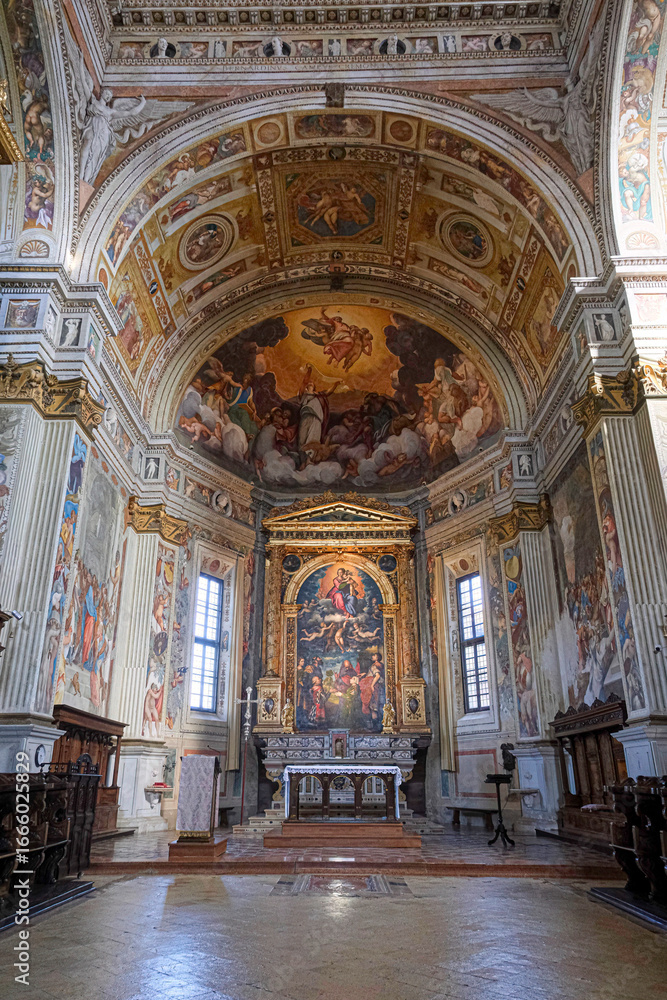 Obraz premium The elaborate interior of a historic Italian church, featuring a richly decorated altar and a magnificent vaulted ceiling covered in Renaissance frescoes.