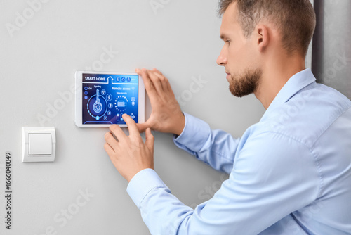 Young man using smart home ...