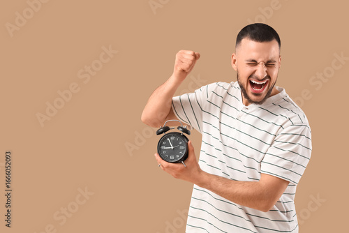 Young man with alarm clock ...