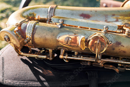 Canvas Print Close-up of weathered vintage saxophone body with patina in natural sunlight