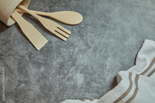 Kitchen background. Spatula, fork, spoon and kitchen cloth on gray marble background.