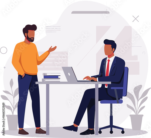 Two male colleagues collaborating in a modern office one standing and one at a desk with a laptop.