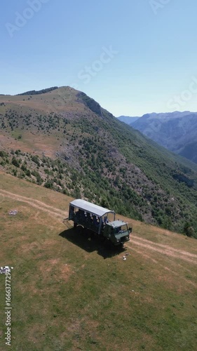 Aerial drone view of a TAM truck driving along rough mountain dirt roads, representing adventure travel, rural transport and off-road experience in nature.
