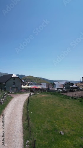 Aerial drone footage flying over traditional stone houses in Lukomir, the highest village in Bosnia and Herzegovina, located on mountain Bjelašnica. Scenic rural settlement with panoramic mountain lan