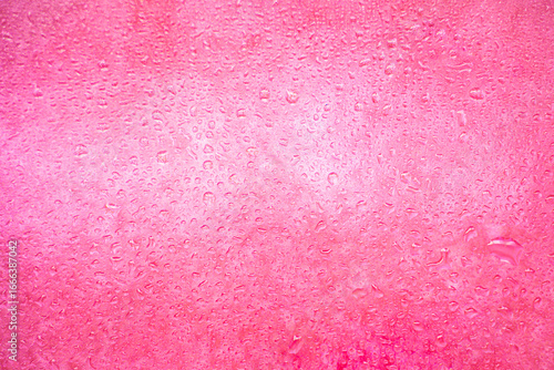background texture for pink raspberry background with shimmering elements and flowing water drops on glass, beautiful bright background with overflows and gradient in slight blur and defocus