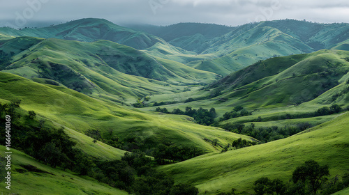 Lush green hills under a cloudy sky create a serene landscape in the countryside