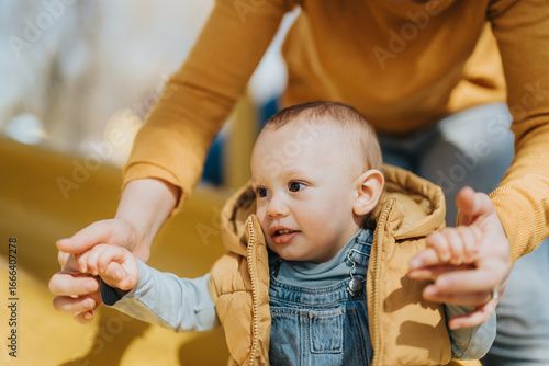 Canvas Print Parent enjoying a bonding moment while guiding cheerful child at a sunny playground filled with joy, warmth, and love, emphasizing the importance of connection and togetherness in childhood