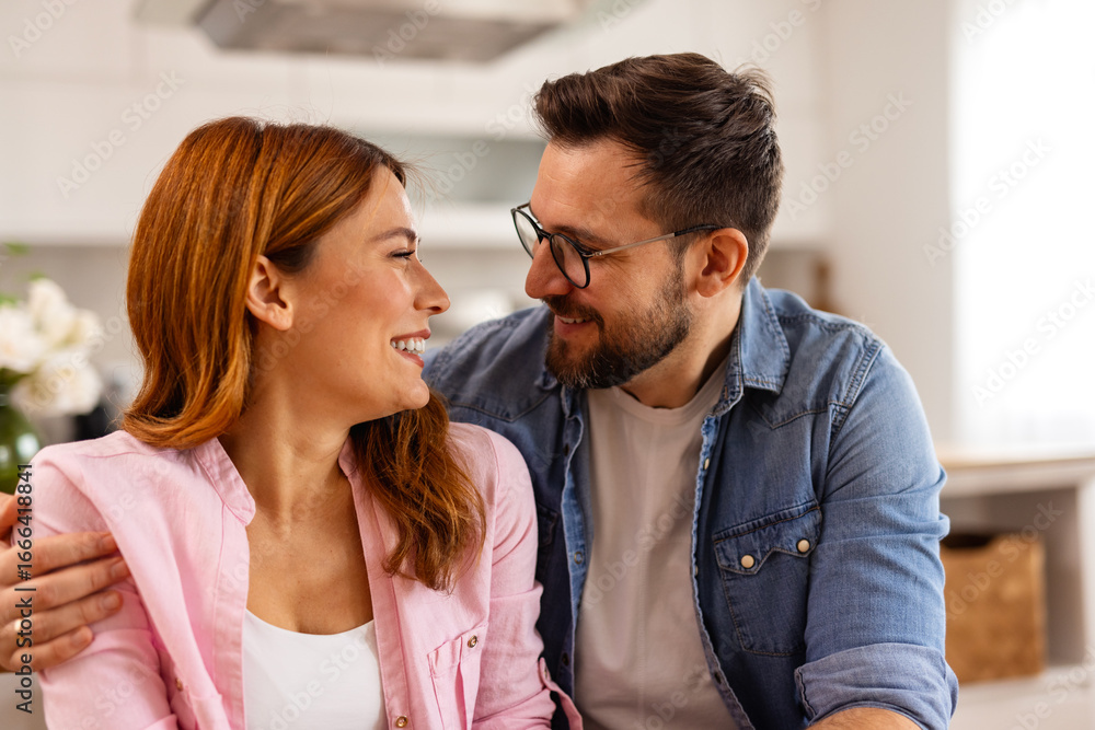 Naklejka premium A couple is sitting at a table together. The scene captures teamwork, communication, or shared activities in a home or work setting, reflecting modern technology and collaboration