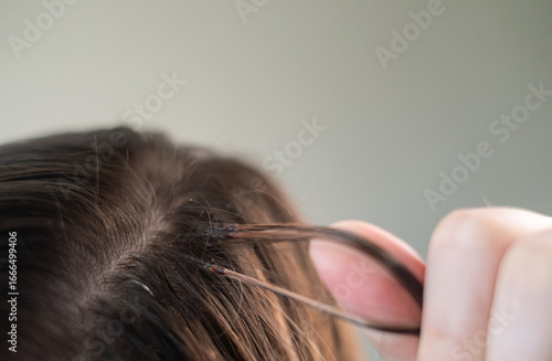 Woman with long hair extensions showing smooth strands and salon care after professional beauty treatment
