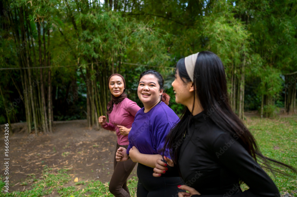 Fototapeta premium Indonesian southeast asian women in a sporty outfit practice running exercise in a public park outdoors. Concept of a Healthy active lifestyle