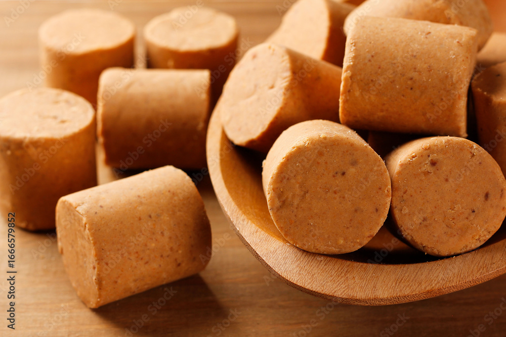 Fototapeta premium Brazilian peanut candy, traditionally known as pacoca or pacoquinha, on a wooden table