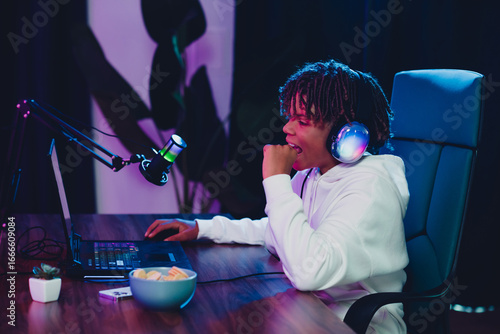 Photography Young male gamer streaming gameplay and engaging with followers in a neon-lit se