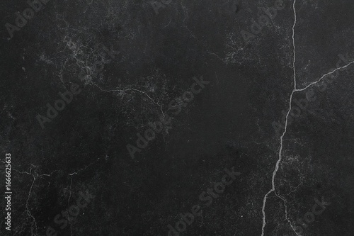 Dark toned black PVC vinyl texture on a concrete floor surface.