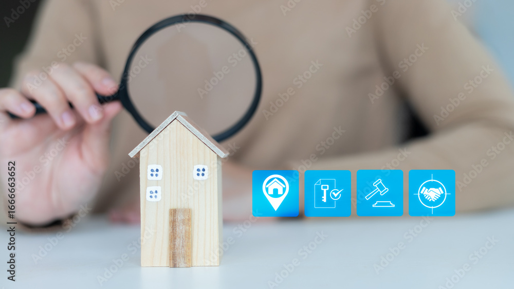 Φωτογραφία Hand holding a magnifying glass inspecting a small wooden house model with real estate icons, symbolizing property investment, housing market analysis, mortgage, legal, contract, and business deal