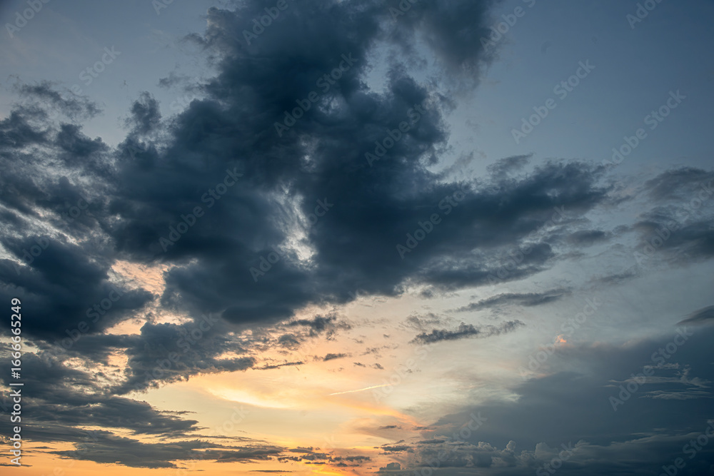 Fototapeta premium Tranquil beauty of a sunset sky, with a stunning array of vibrant colors and dramatic cloud formations.