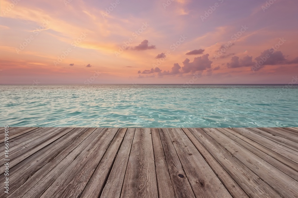 Fototapeta premium A wooden deck extends into the retreating ocean waters beneath a colorful sunset sky.